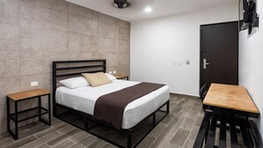 Une chambre à coucher moderne avec un lit, des tables de chevet, un bureau et une armoire.