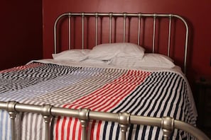 A bed with a metal frame and a striped bedspread.