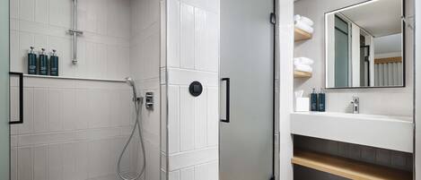 A modern bathroom with a shower, toilet, and sink.