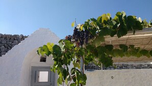 Un edificio blanco con pared de piedra y puerta de madera.