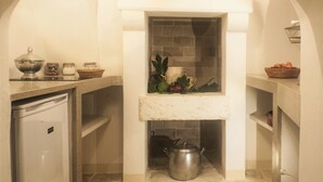 Una cocina compacta con horno empotrado, un lavamanos y una encimera con distintos utensilios de cocina.