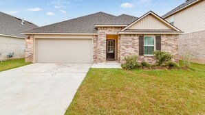 A single-story house with a garage, brick exterior, and a small front yard.
