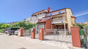 A two-story residential building with a balcony on the upper floor, a gated entrance, and a parked car in front. - Balcony with sea view, FAZANA, 280m to the main beach, 400m to the old town  (Fažana)