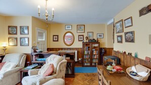 A cozy living room with a fireplace, comfortable seating, and a bookshelf. - Charming Historical Cottage in Scarborough (Scarborough)