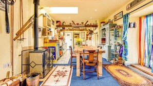 A cozy kitchen with a wooden table and chairs, a stove, and various kitchen items. - Family Country Cottage With a Private Valley View (Scarborough)