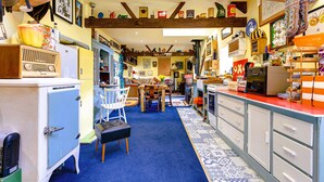 A vintage kitchen with a blue carpet, wooden beams, and various kitchen appliances. - Family Country Cottage With a Private Valley View (Scarborough)
