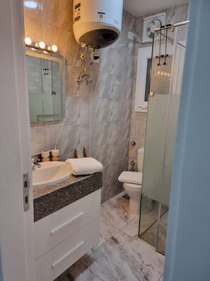 A modern bathroom with a marble floor, a double sink vanity, a glass shower enclosure, and a toilet. - Stunning New 2-bed Apartment Near El Gouna (Hurghada)