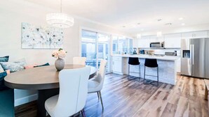 A modern kitchen with a dining area, large windows, and a chandelier. - The Easy of Old Town - Luxury & Location! (Scottsdale)