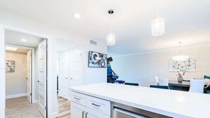 A modern kitchen with white cabinetry, stainless steel appliances, and pendant lighting. - The Easy of Old Town - Luxury & Location! (Scottsdale)