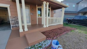 A residential house with a covered porch, a garage, and a driveway.