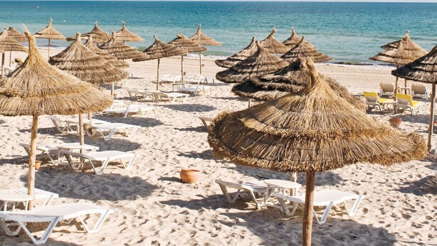 A beach with thatched umbrellas and white lounge chairs. - HOTEL DAR TAOUFIK (Djerba Midun)