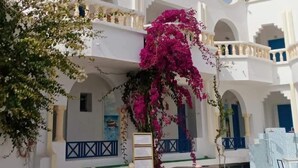A white building with balconies, a fountain, and potted plants. - HOTEL DAR TAOUFIK (Djerba Midun)