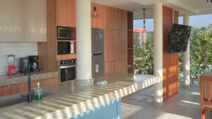 Una cocina moderna con armarios de madera, encimera de granito y horno empotrado.
