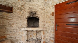 A stone fireplace with a wooden door and a shelf above it. - Stone House Lozica Vela Luka (Vela Luka)