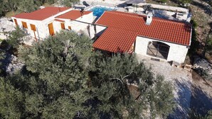 A stone villa with a swimming pool, red-tiled roofs, and a stone wall. - Stone House Lozica Vela Luka (Vela Luka)