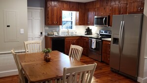 A kitchen with wooden cabinets, a stainless steel refrigerator, a microwave, and a dishwasher. - 6 Bed/4 Bath whole house duplex, minutes from golf, restaurants, and the beach! (Murrells Inlet)