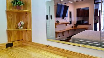 Un dormitorio con un espejo grande, estantes de madera y una cama.