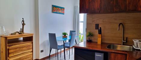 Una cocina moderna con encimera de madera, un lavabo y un comedor con sillas y una mesa.