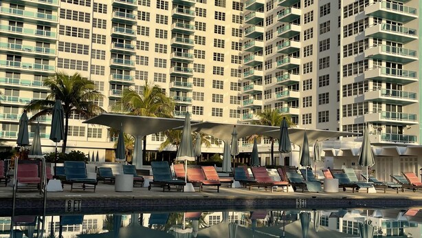 A high-rise hotel with a swimming pool, multiple balconies, and outdoor seating areas. - 2bd2bth Partial Ocean view Ste w/ balcony, Pool, nearby dining, beach access (Miami Beach)