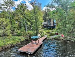 A wooden dock extending into a river, surrounded by lush greenery and trees. - Lakefront Sunsets, Hot Tub, Pool Table, Wet Bar, Kayaks, Canoe, Fire Pit, 2 King Beds, 75" TV (Lake Ariel)