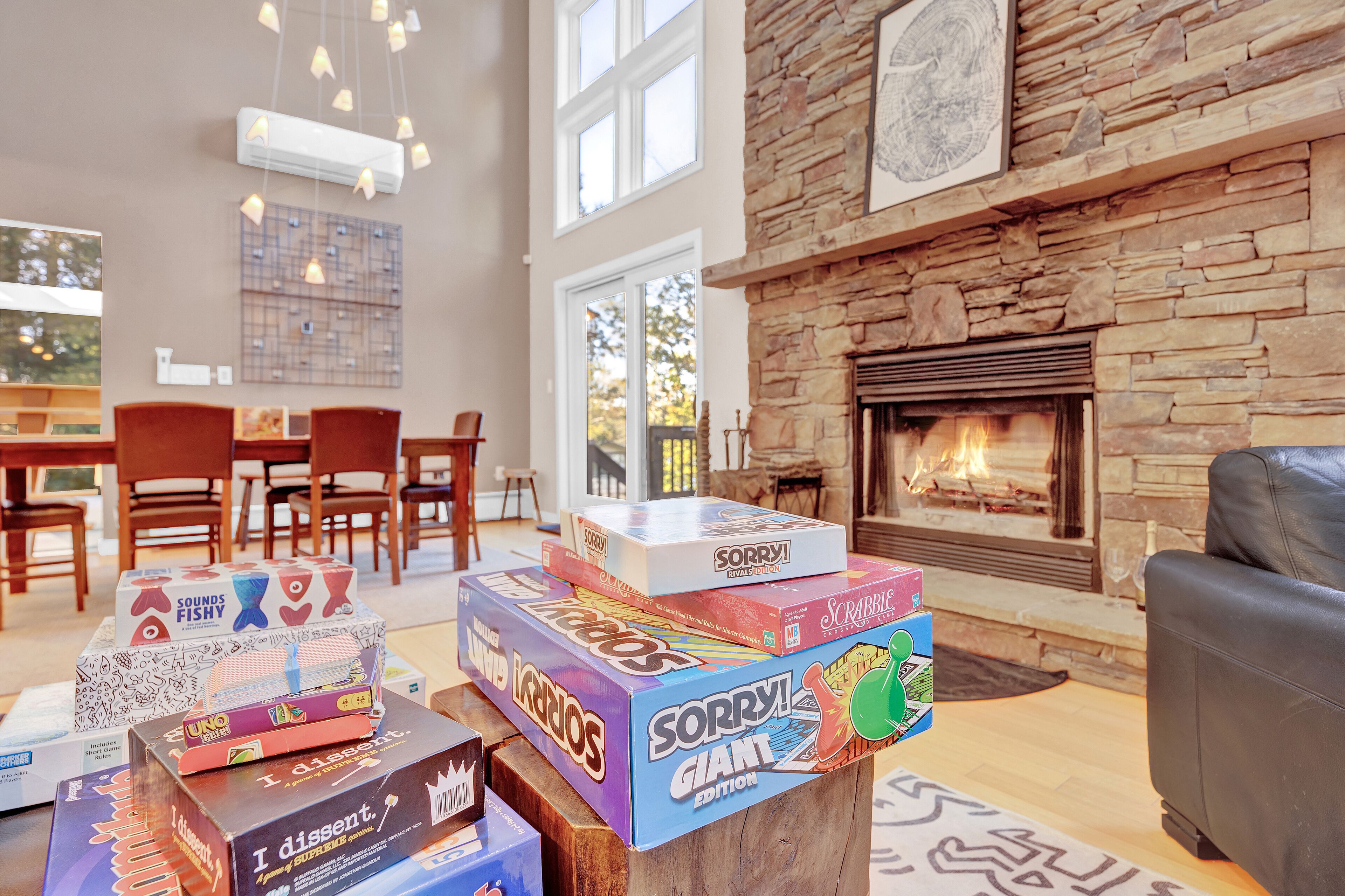Una sala de estar acogedora con chimenea, muebles de madera y una variedad de juegos de mesa sobre una mesita de centro.