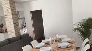 A modern dining area with a wooden table set for four, surrounded by white chairs. - Independent villa with private pool, 5 min from the beach! (San pedro del Pinatar)