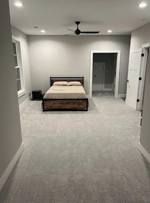Cozy bedroom with a single bed, ceiling fan, and doors leading to adjacent rooms.