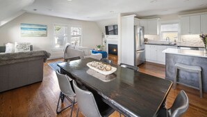A modern kitchen with a central island, white cabinetry, and a fireplace. - Stunning Home Mins to Boston w/Parking & Laundry (Somerville)