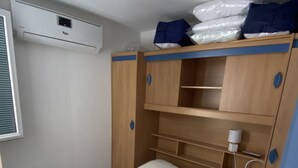 A bedroom with a bed, a wardrobe, and a shelf unit.
