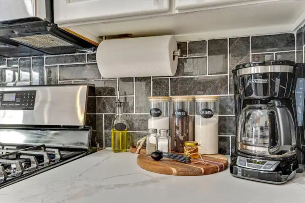 A modern kitchen with a gas stove, a coffee maker, and various kitchen appliances.