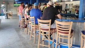 Eine Bar mit Holzhockern und einer Theke.