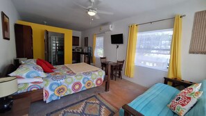 Cozy retreat with a bed, desk, and ceiling fan, perfect for a comfortable stay.