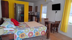Ein Schlafzimmer mit einem Bett, einem Nachttisch und einem Schreibtisch mit Stühlen.