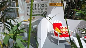 Relax in a serene outdoor space surrounded by lush greenery and a vibrant geometric pattern.
