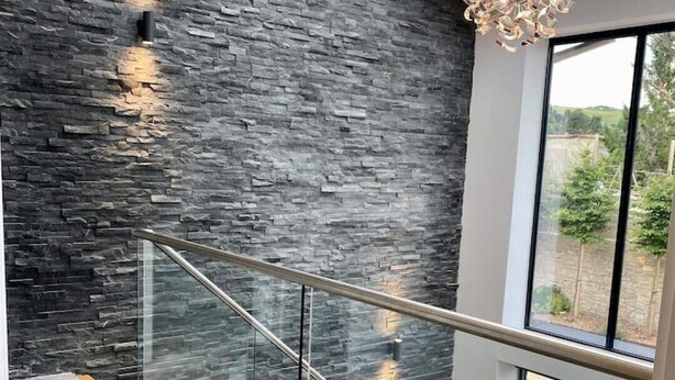 A modern staircase with glass railings and a stone wall. - Stunning modern home set in beautiful grounds. (Corston)