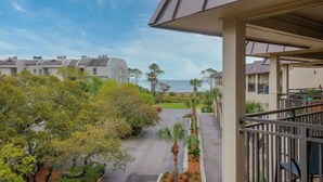 A residential building with a covered outdoor area, a view of the sea, and a well-maintained garden. - 3rd Floor 100% Remodeled Condo- Ocean Views (Hilton Head Island)