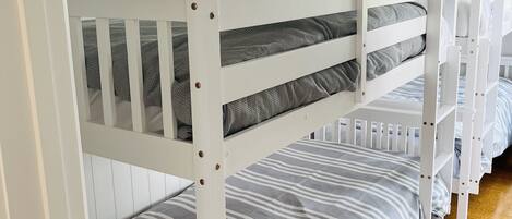 A bunk bed room with white walls and a sloped ceiling.