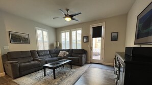 A living room with a sectional sofa, a coffee table, and a ceiling fan. - Coastal Vibes • Cal King Bed • Trails (Folsom)