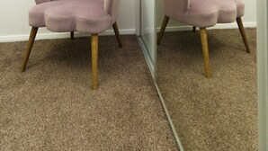 A room with a pink armchair and a mirror reflecting the chair. - West Park House (Leeds)