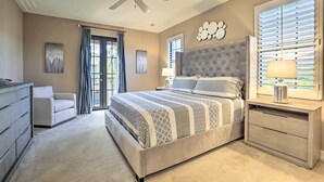 A bedroom with a large bed, a nightstand with a lamp, a ceiling fan, and a view of the outdoors through the window. - Ole at Lely Resort Condo w/ Pool Access! (Naples)