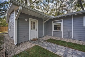 Uma casa residencial com varanda frontal, porta e janela.