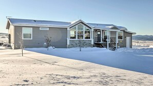 A modern two-story house with a large front porch, a garage, and a snow-covered driveway. - Cozy Home: Mtn Views, A/C, in Heart of Star Valley (Etna)