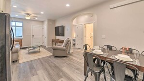 A modern kitchen with a dining area, a TV mounted on the wall, and a ceiling fan. - Cozy Home: Mtn Views, A/C, in Heart of Star Valley (Etna)