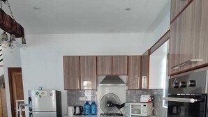 A modern kitchen with stainless steel appliances, wooden cabinets, and a central island. - Beautiful House With Private Pool in Mauritius (Albion)