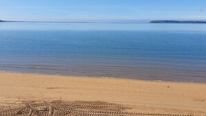A beach with a clear sky and calm water. - Beach House (Duncannon)