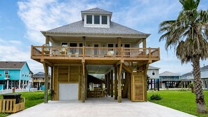 Ein zweistöckiges Haus mit Balkon, Garage und Veranda.