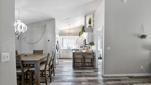 Cozinha moderna com armários brancos, uma ilha central e um pendente.