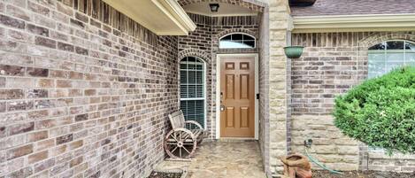 A brick house with a stone archway, a wooden door, and a mailbox.