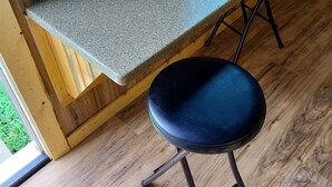 A wooden interior with a granite countertop and two black stools. - Cabin/Farmhouse w/fire pit and wide open spaces (Haslet)
