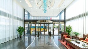 A spacious lobby with a modern design, featuring a central seating area with sofas and a coffee table, a chandelier, and a glass door entrance. - Yong'anzhou Hotel (Mengshan)